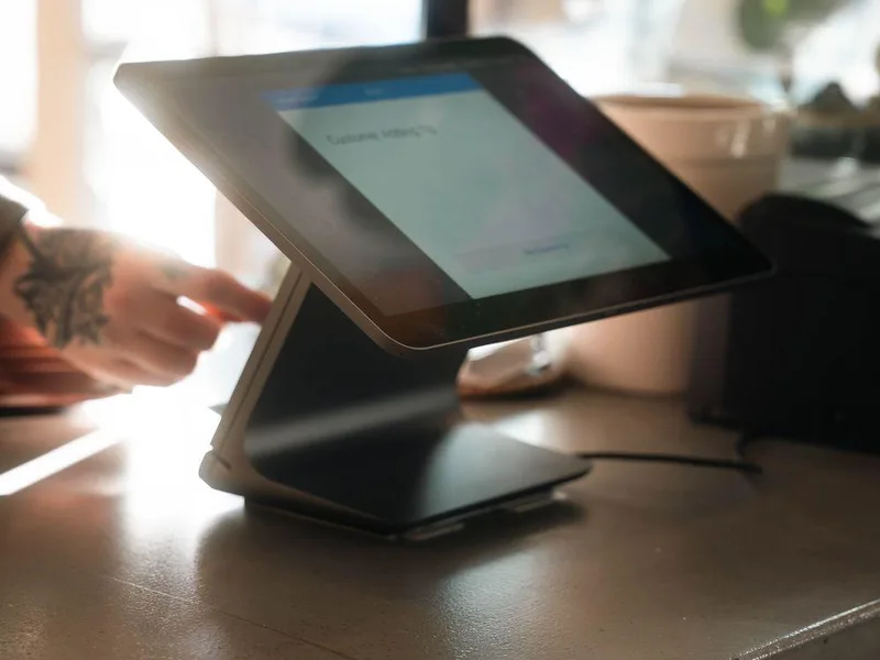 Tablet point-of-sale terminal on a sunlit cafe counter