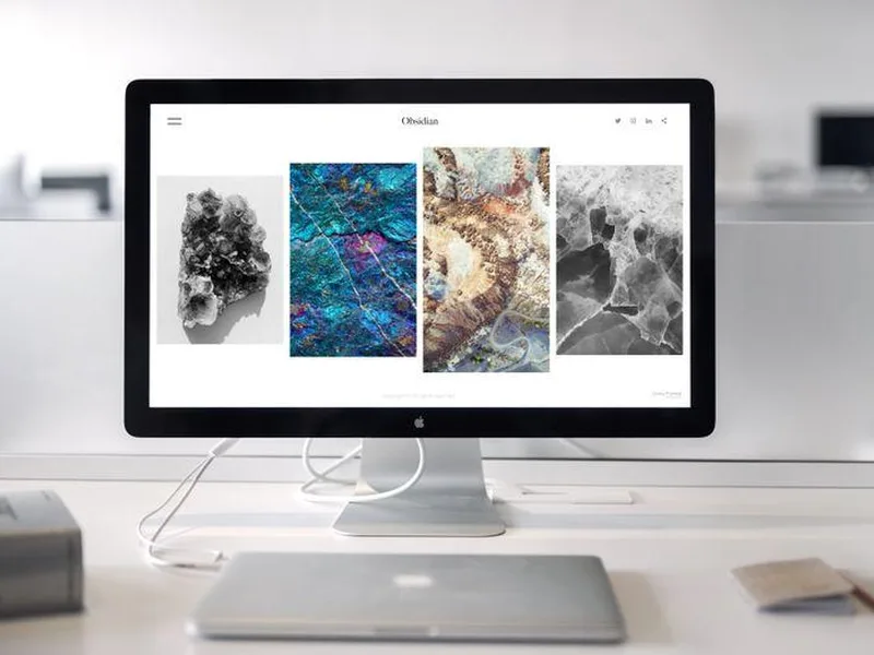 Website displayed on a desktop computer in a bright white workspace