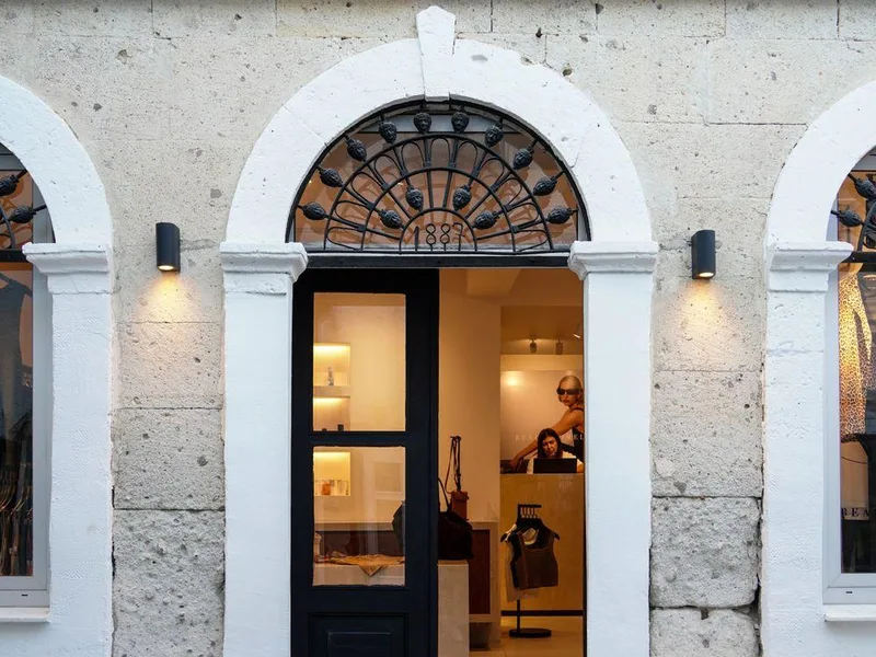 Open boutique entrance framed by a pale stone storefront